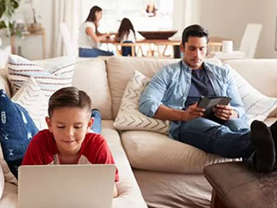 A child on the couch learning more about saving and spending money by playing games online.
