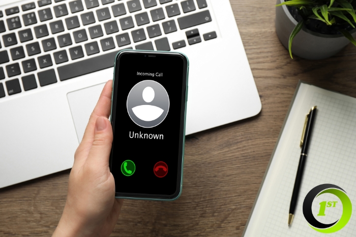 laptop in background and phone showing unknown incoming call