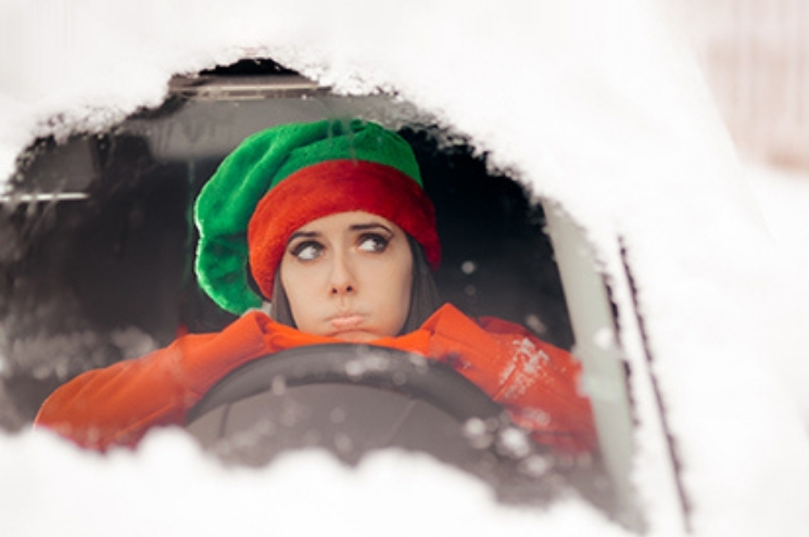 woman looks out from inside a snowbound vehicle